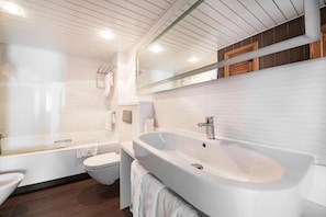 Ein modernes Badezimmer mit Badewanne, Toilette und Waschbecken.