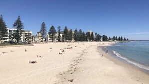 A beach with buildings and trees along the shore. - Stylish 2-bed With Terrace, 3-min Walk to Beach (Adelaide)