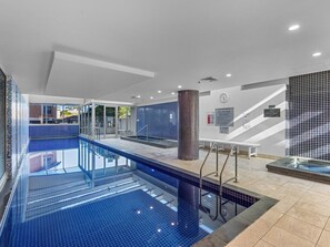 An indoor swimming pool with clear water, tiled walls, and a bench. - Stylish 2-bed With Terrace, 3-min Walk to Beach (Adelaide)
