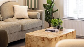 Ein Wohnzimmer mit einer Couch, einem Couchtisch und einer Topfpflanze.