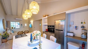 A modern kitchen with a central island, stainless steel appliances, and a white marble countertop. - NEW 2BR Escape | Plunge Pool & BBQ | Near Beaches (Noord)