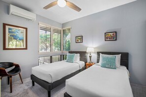 A hotel room with two beds, a ceiling fan, an air conditioning unit, a chair, and artwork on the walls. - Grand Champions | Ocean View 4 BR, Sleeps 10 | Car Incl. w/ 6+ Nights | GCH ML-3777 by KBM (Wailea)