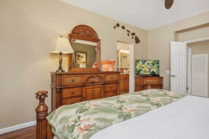 A bedroom with a bed, dresser, mirror, television, and a door. - 2 Grand Champions | Treeline View | Sleeps 10 | Free Car w/ 6+ Nts | ML-3777 (Wailea)