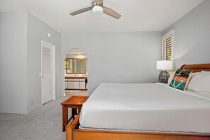 A bedroom with a bed, a bedside table, a ceiling fan, a nightstand, a lamp, and a window with shutters. - 2 Grand Champions | Treeline View | Sleeps 10 | Free Car w/ 6+ Nts | ML-3780 (Wailea)