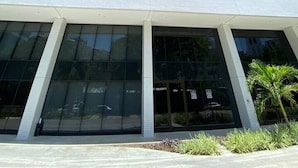 Ein hohes, modernes Gebäude mit Glasfassade und flachem Dach.