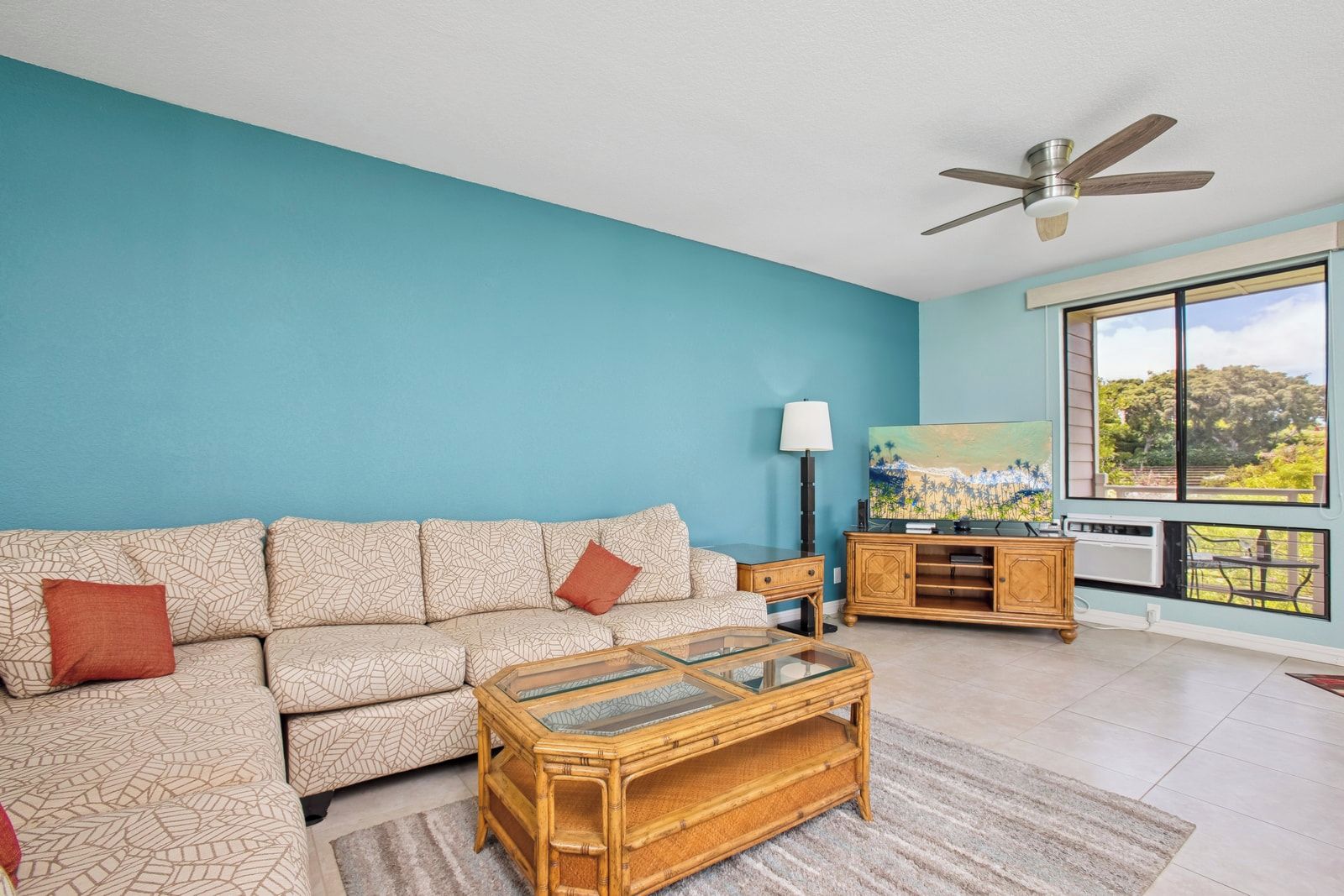 A living room with a sofa, coffee table, and a television.