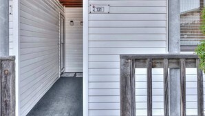 Ein schmaler Korridor mit einer Holztür, einem Schild mit der Nummer 131 und einem Holzzaun.