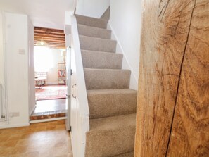 Eine Treppe mit Teppichstufen führt zu einer offenen Tür.