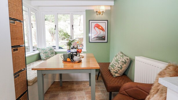 A cozy room with a wooden table, a bench, and a radiator. - Quince Cottage (Lewes)