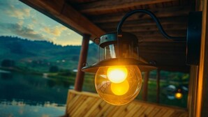 A lantern hanging inside a wooden structure with a view of a lake and hills outside.
