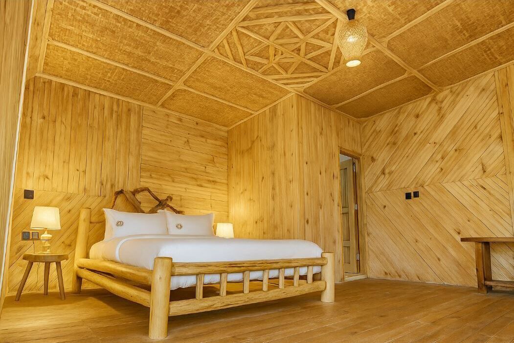 Una stanza in legno con un letto, un comodino e una lampada a sospensione.