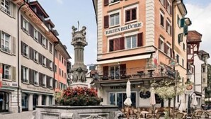 A building with a sign 'KRÜENBRÜCKE' and a statue in front. - KBCityRooms (Lucerne)