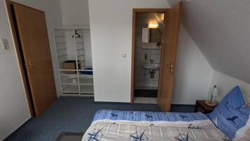 Una camera da letto con un letto, un armadio, un bagno e una cabina armadio.