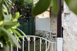A courtyard with a white table and chairs, a whiteboard, and a stone wall. - N308 - Numana, comfortable three-room apartment in the center (Numana)