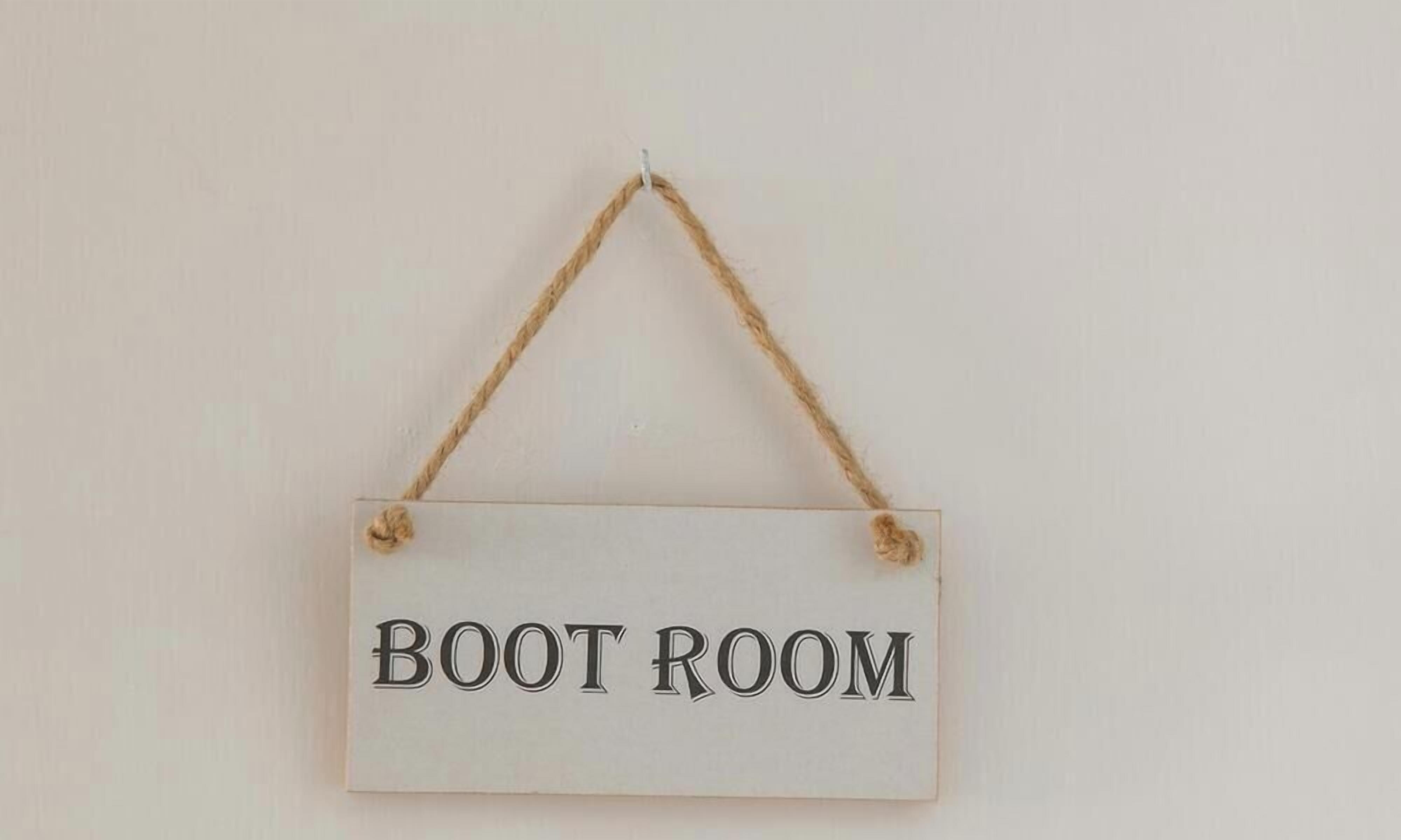 Une pancarte portant l’inscription « SALLE DES CHAUSSURES » est accrochée à un mur.