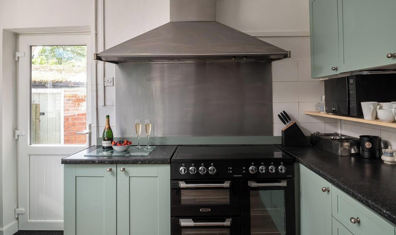 A kitchen with a stove, oven, and a large range hood.