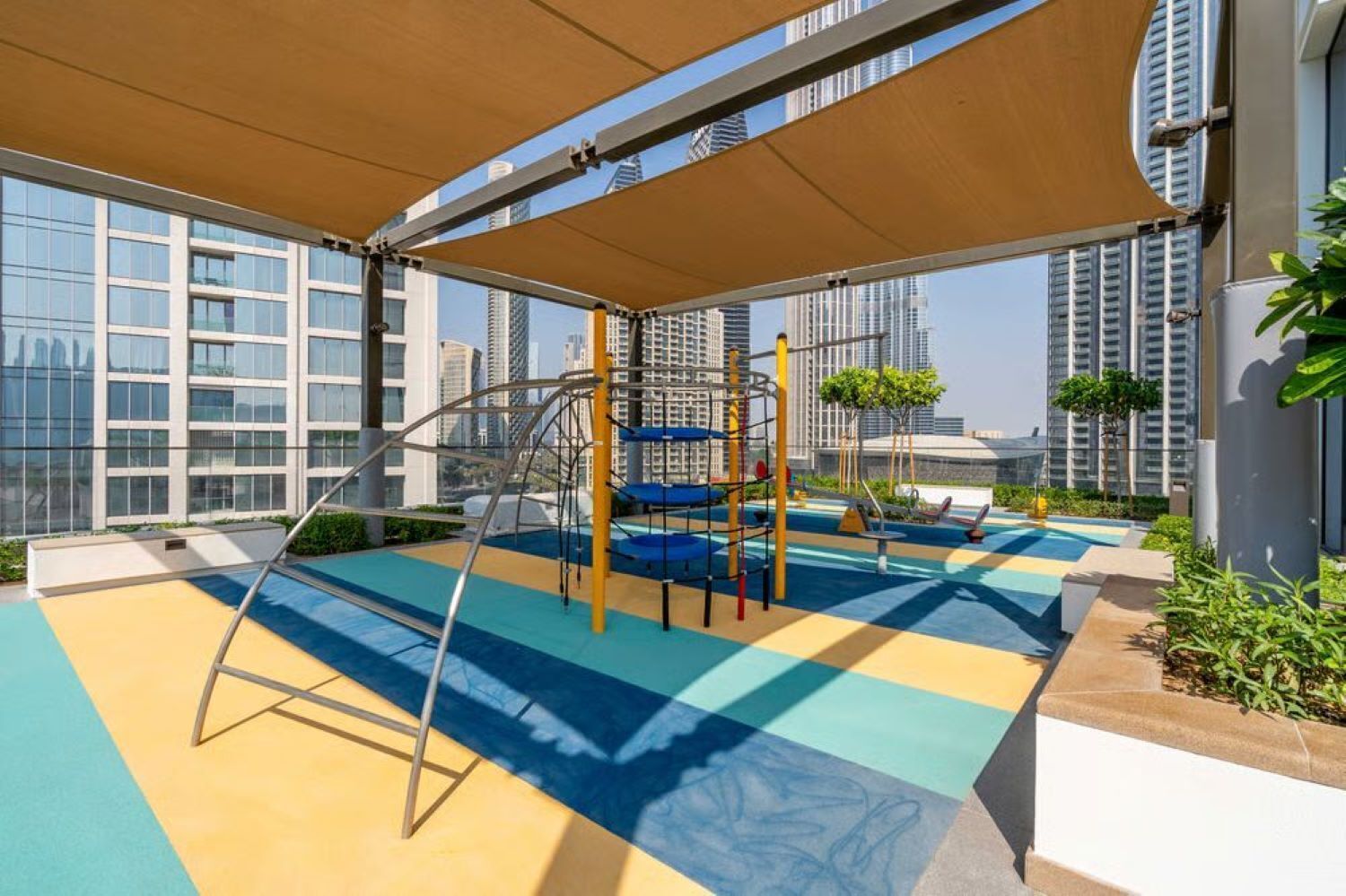 Un patio de juegos en la azotea con estructuras de escalada y una zona de juegos blandos.