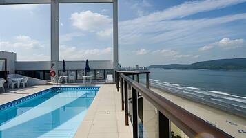 Une piscine sur le toit offrant une vue sur la mer et le panorama de la ville.