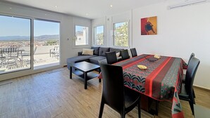 A spacious room with a large dining table, a sofa, and a view of the cityscape through large windows. - BONREPOS 2 Roses / Roses - INTERimmo (Rosas / Roses)