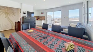 A modern living room with a dining area, a kitchen, and a balcony with a city view. - BONREPOS 2 Roses / Roses - INTERimmo (Rosas / Roses)