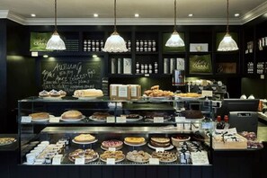 A bakery display with various baked goods and a chalkboard menu. - The Hummingbird 1 Bedroom by Kensington Gardens (London)