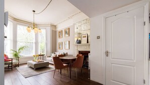 A room with a fireplace, a dining area, and a sofa. - Victorian Blush 1BR Near Portobello Notting Hill (London)