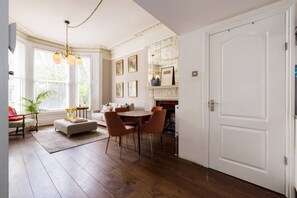 Ein Zimmer mit Kamin, Essbereich und Sofa.