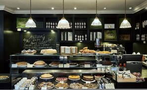 Eine Verkaufstheke einer Bäckerei mit verschiedenen Backwaren und einer Kreidetafel mit Speisekarte.