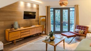 A modern living room with a wooden cabinet, a flat-screen TV, a sofa, and a coffee table. - Neon Melody Playful 2 Bedrooms by London Bridge (London)