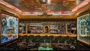 A bar with a traditional Asian design, featuring a central dragon statue, multiple shelves of bottles, and a ceiling with intricate artwork. - Cosy and Stylish Chelsea 2 Bedroom Flat (London)
