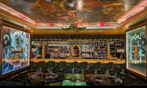 Eine Bar mit traditionellem asiatischen Design, inklusive einer zentralen Drachenstatue, mehreren Flaschenregalen und einer Decke mit aufwendigen Kunstwerken.