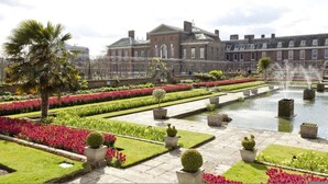 A formal garden with a fountain, manicured flower beds, and a classical building in the background. - Whoops-a-daisy 3 Bedroom in Notting Hill (London)