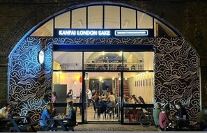 A restaurant with a wave-patterned exterior and a sign reading 'KANPAI LONDON SAKE.' - The City Song 1 Bedroom Apartment in Rotherhithe (London)