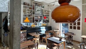 Een modern interieur met een leren bank, houten tafels en een grote klok aan de muur.