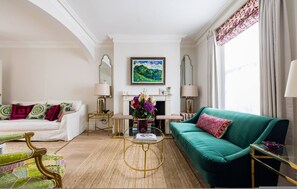 A living room with a sofa, armchairs, a fireplace, and a painting on the wall. - The Impressionist s Fireplace 4 BR Home in Chelsea (London)