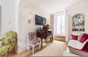 A room with a desk, a chair, a sofa, a television, and a bookshelf. - The Impressionist s Fireplace 4 BR Home in Chelsea (London)