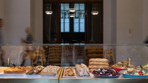 Un buffet proposant divers plats, une fenêtre avec vue et des lustres.