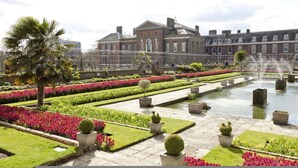 A formal garden with a fountain, manicured flower beds, and a classical building in the background. - Kensington Luxury - 2 Bedrooms (London)