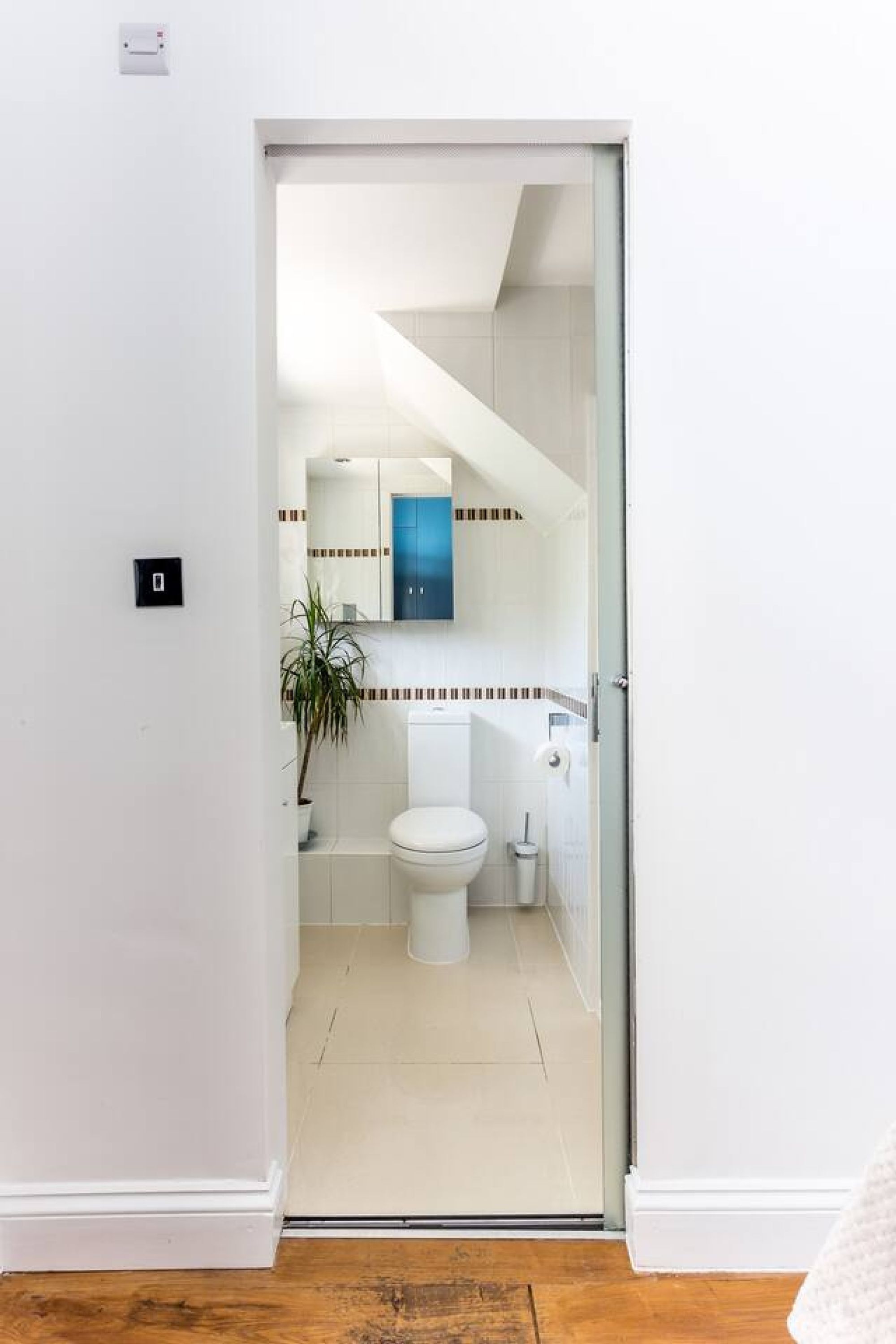 A bathroom with a toilet, sink, and mirror.