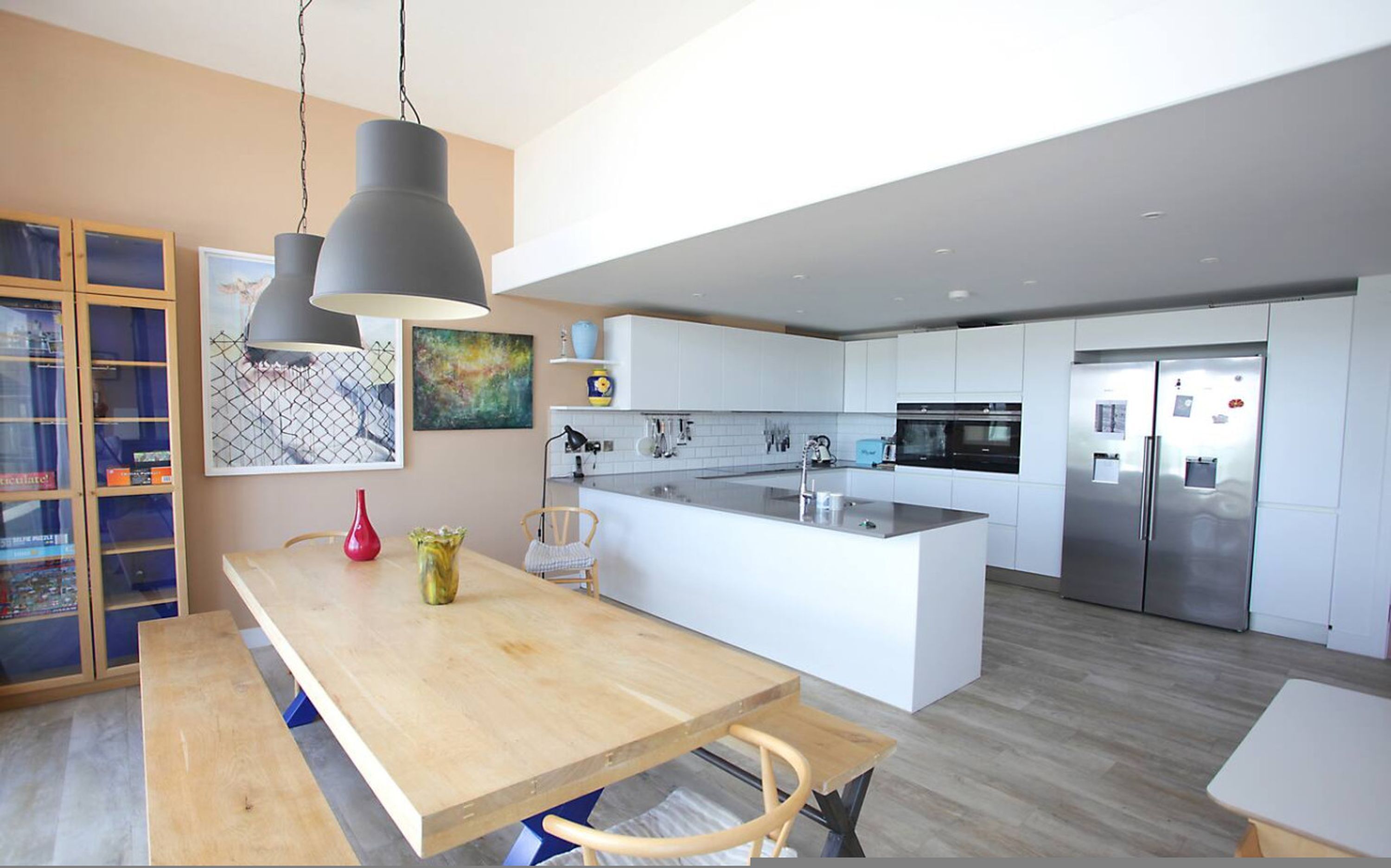 A modern kitchen with a central island, stainless steel appliances, and pendant lighting.