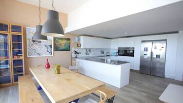 A modern kitchen with a central island, stainless steel appliances, and pendant lighting.