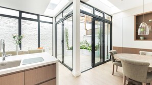 Una cocina moderna con un amplio ventanal, un comedor con mesa y sillas, y vistas al exterior.