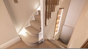Una escalera con barandilla acolchada y escalones de madera.