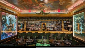 A bar with a traditional Asian design, featuring a central dragon statue, wooden furniture, and a ceiling with intricate artwork. - Retreat to a Stylish 1 Bedroom Flat in Chelsea (London)