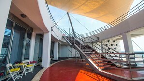 Ein modernes Interieur mit einer geschwungenen Treppe, einer Sitzgelegenheit im Freien und großen Fenstern.