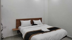 A hotel room with a bed, a nightstand, and a ceiling fan.