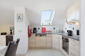 Eine moderne Küche mit Geschirrspüler, Backofen und Oberlicht.