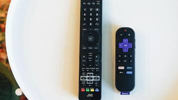 Two remote controls on a white surface.