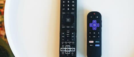 Two remote controls on a white surface.
