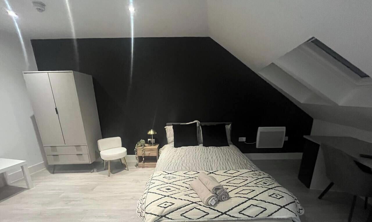 Une chambre à coucher avec un lit, une armoire blanche, un bureau et une chaise.